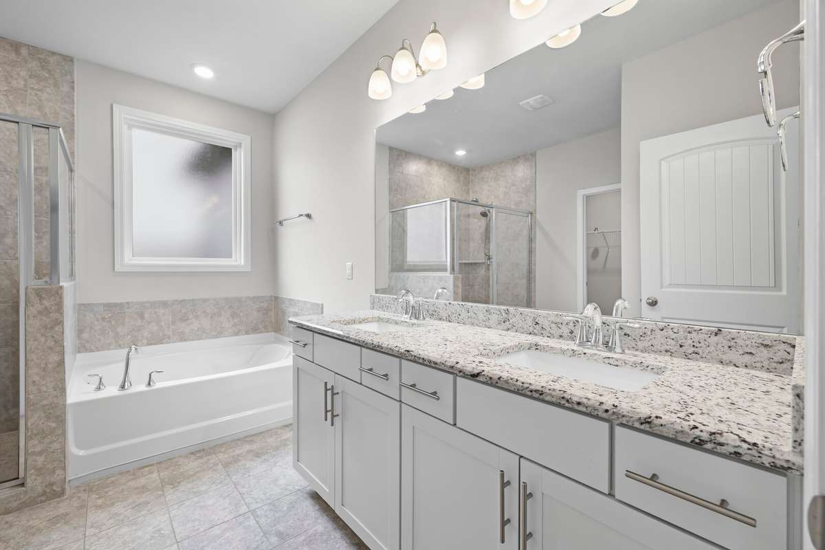 Primary bathroom with double sinks, a soaking tub and walk-in tile shower