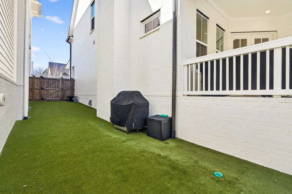 Off of the covered porch is a turfed area for dogs or grilling supplies