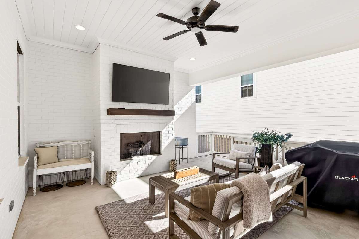 The covered porch off of the kitchen/living room with gas fireplace and privacy
