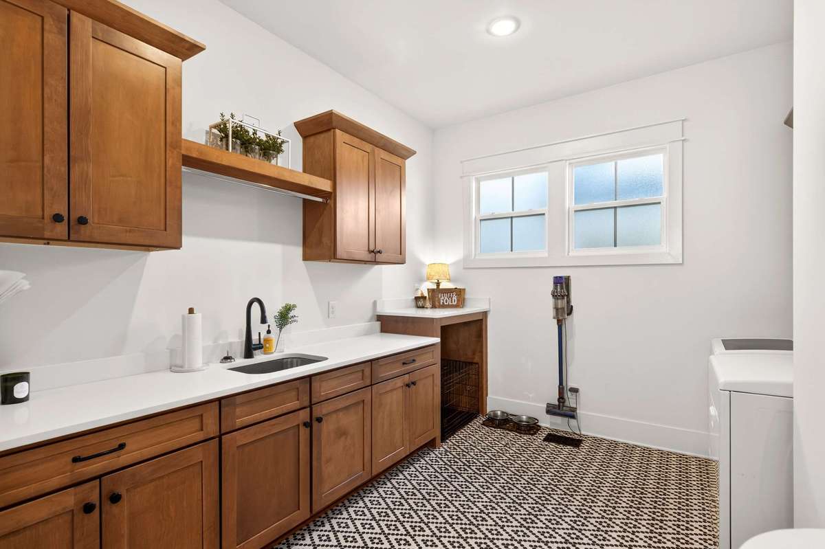 What laundry dreams are made of! This room offers plenty of cabinetry and space to make the dreaded task more pleasant. There is a great space that can be used for a dog kennel as well and this room also has a Dutch door for containing pets.