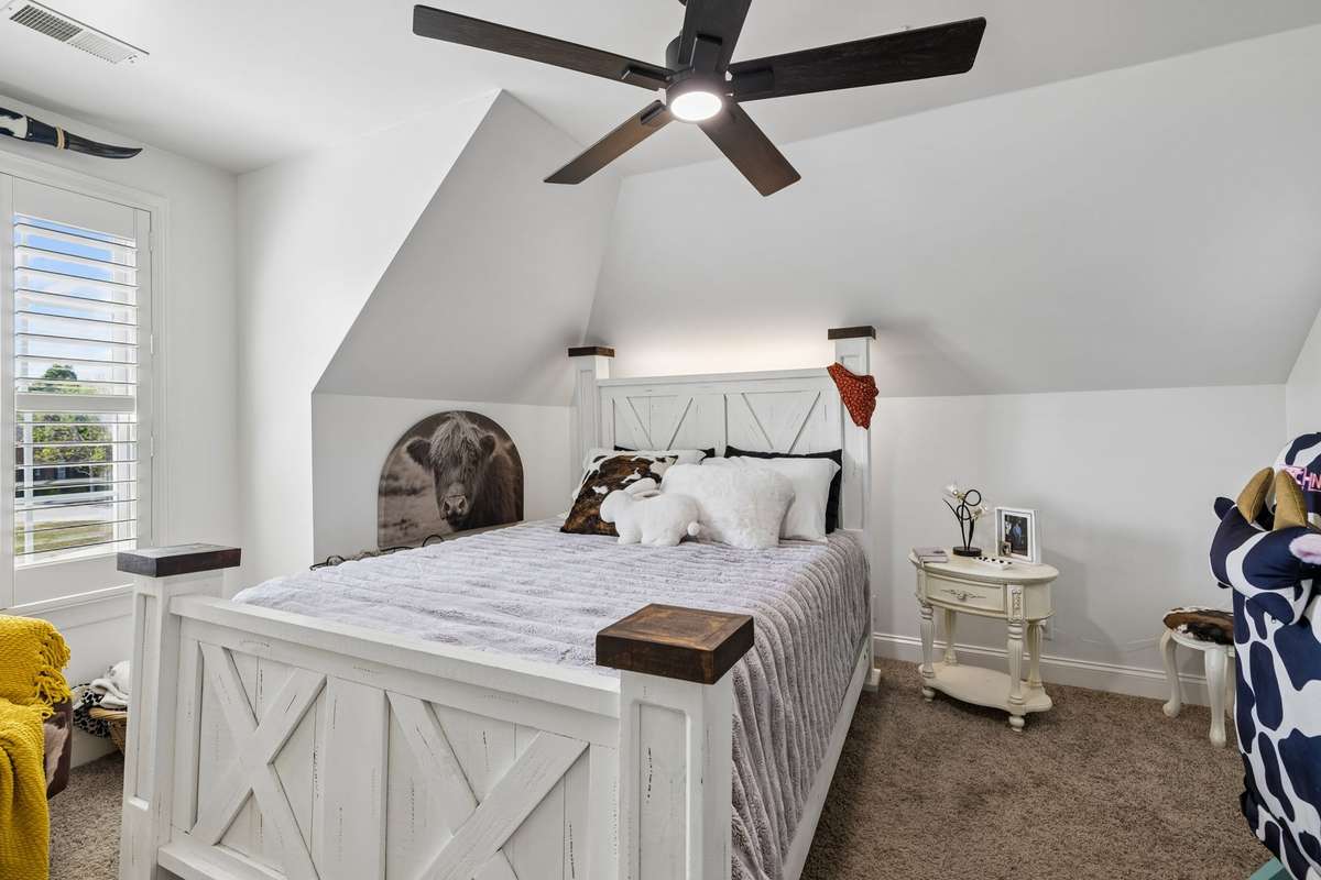 Third bedrooms upstairs with ceiling fan, double windows with plantation shutters and ensuite bath