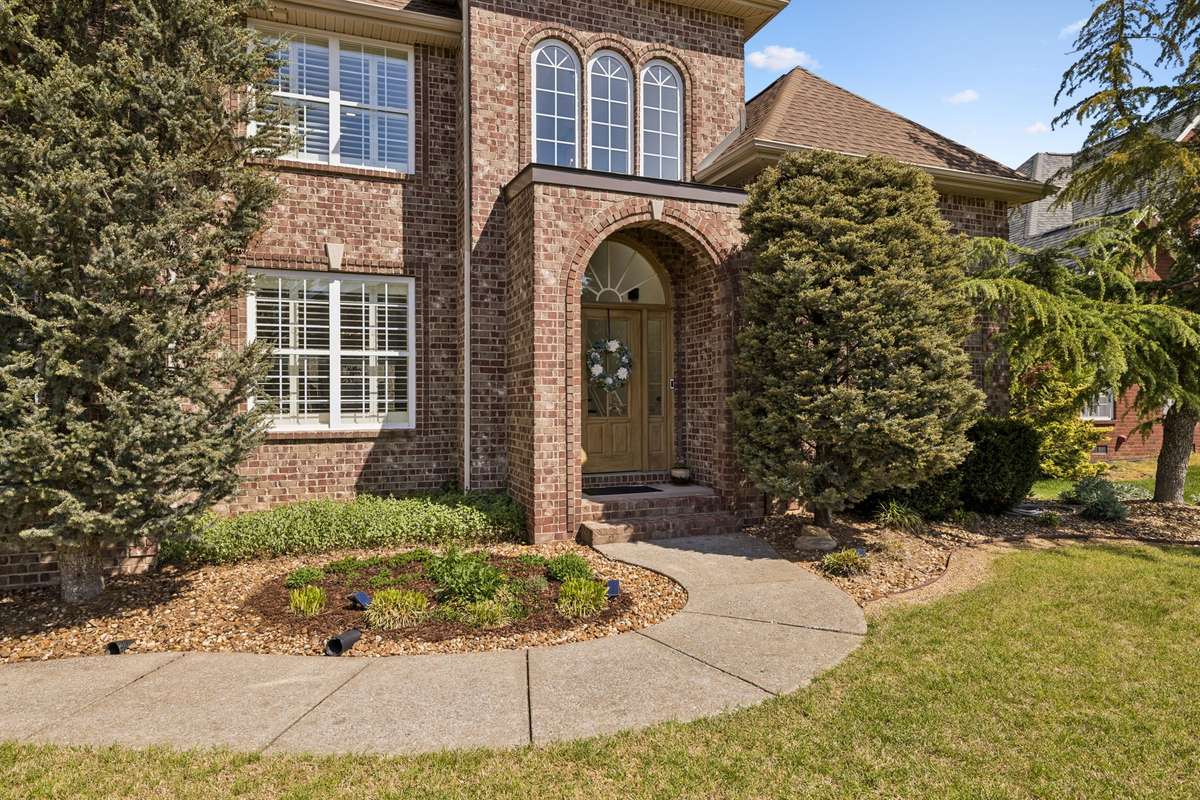 Inviting arch to covered porch and front door entry