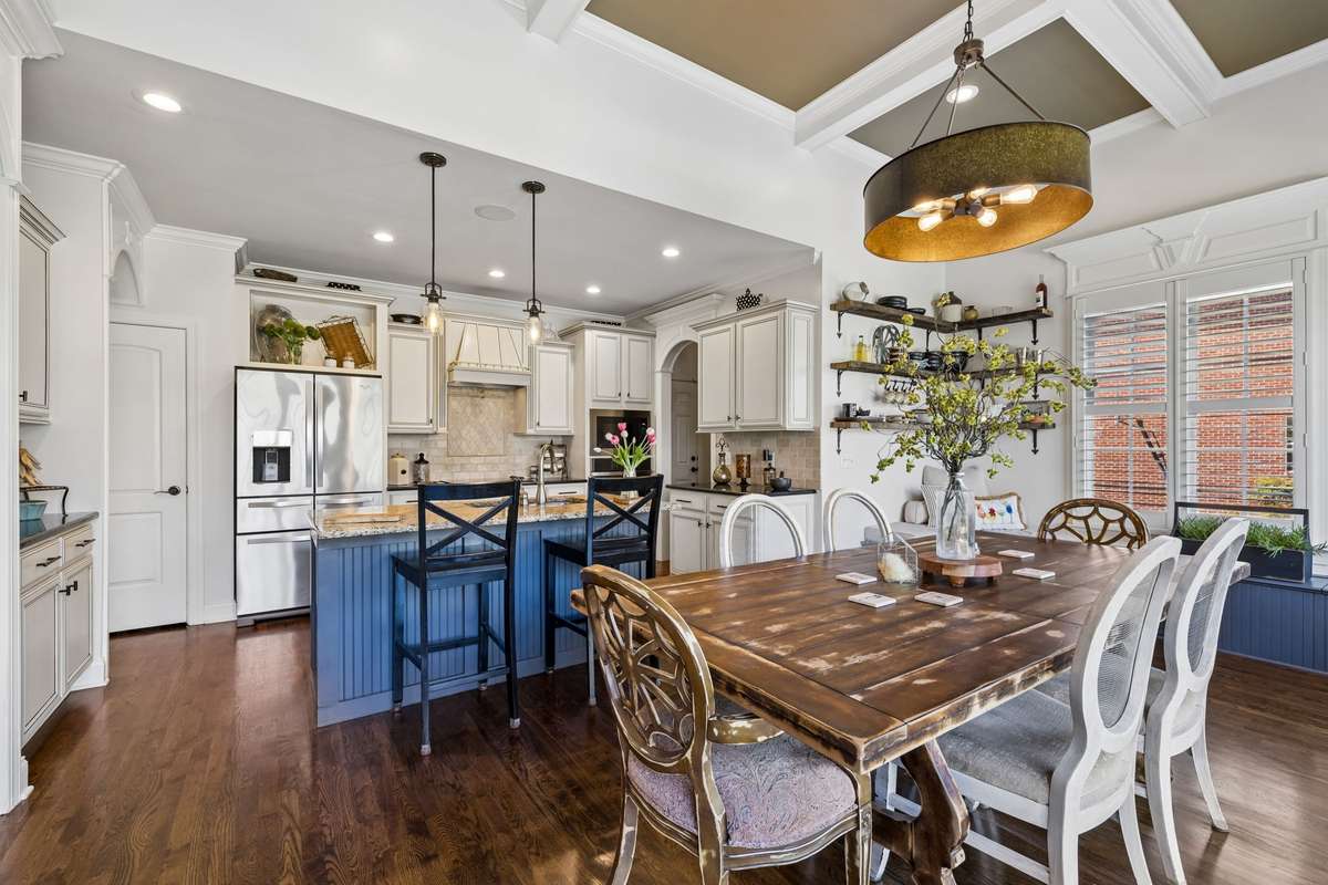 Kitchen has custom white cabinets with glazing and custom painted island