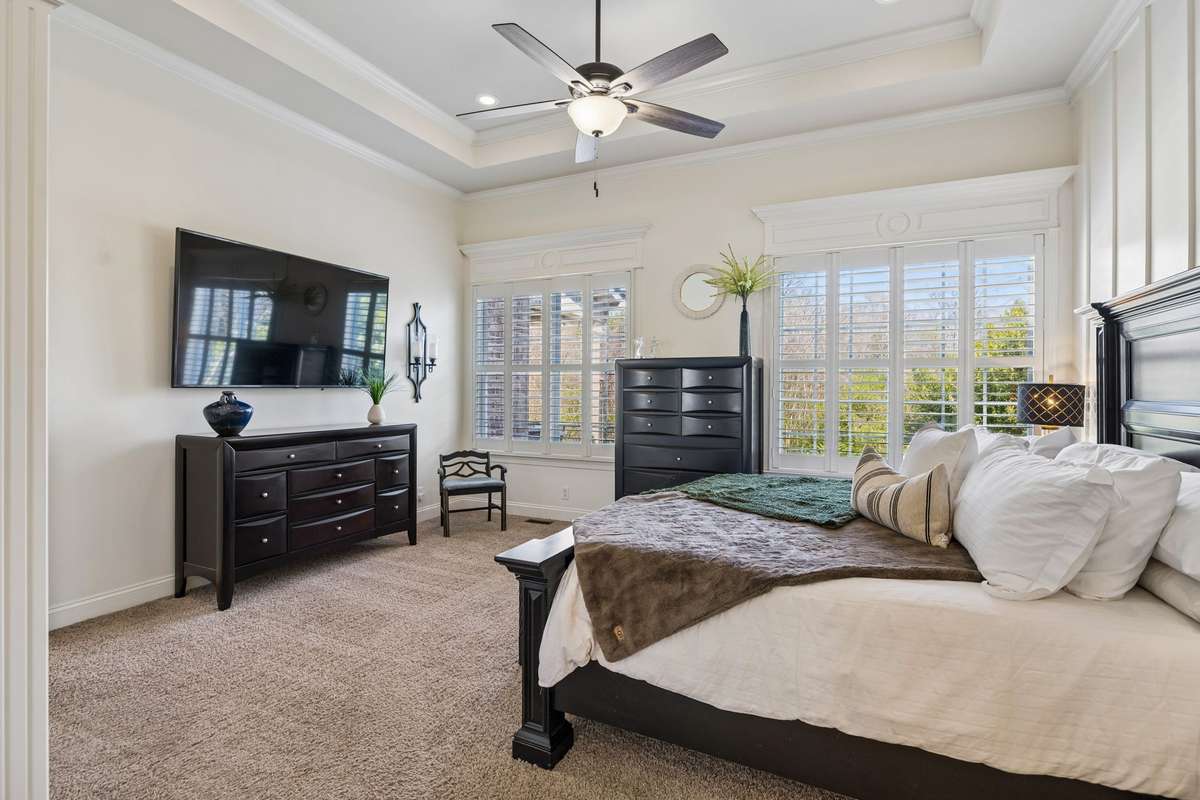 Primary bedroom provides windows overlooking the pool and backyard
