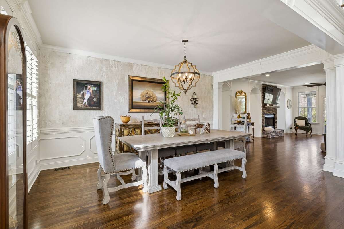 Formal dining room with wainscoting, custom paint, trim details and decorative chandlier