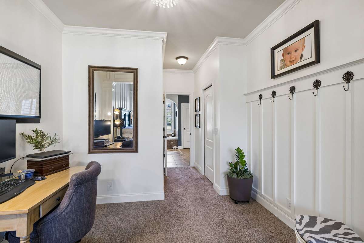 Primary suite sitting area leading to walk-in closets and private bath