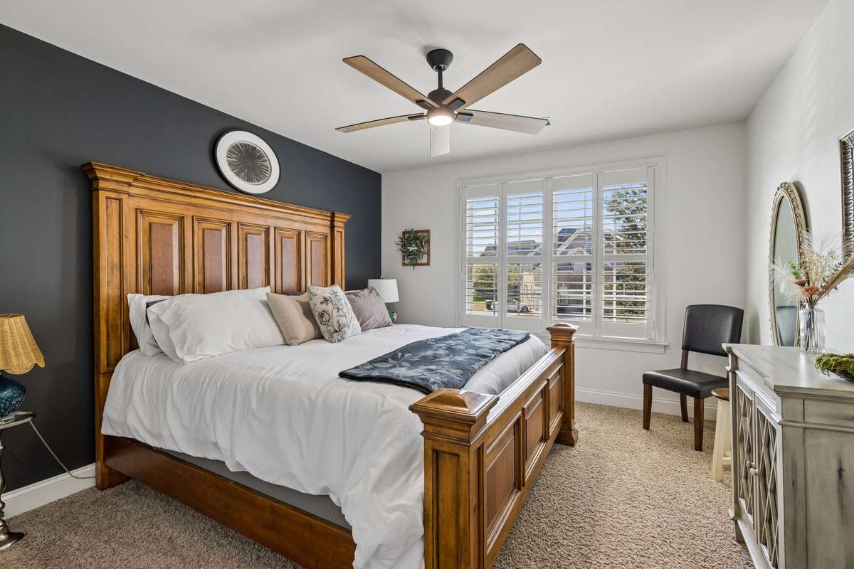 One of three secondary bedrooms upstairs - this one with a wall of windows with plantation shutters and ceiling fan