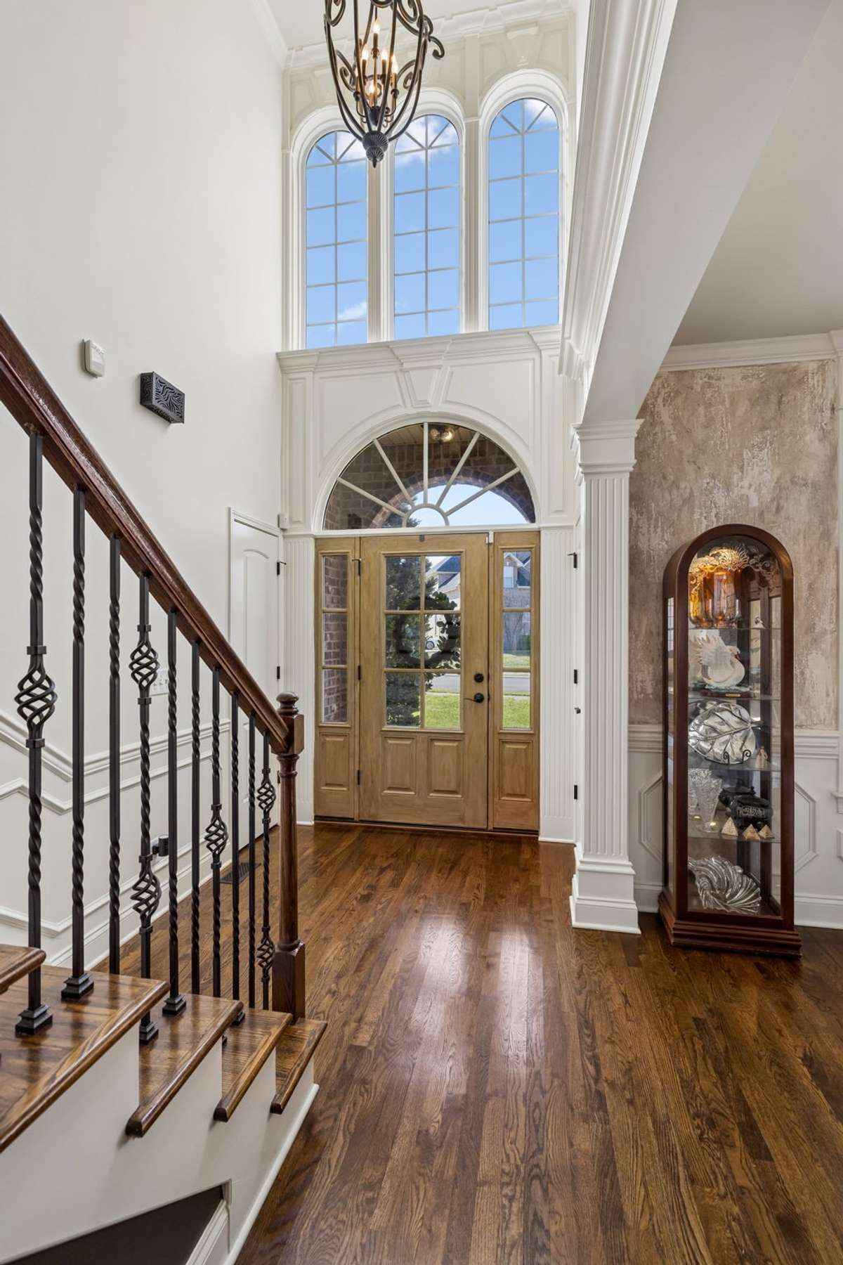 Front door with glass panels, sidelights and arched window above