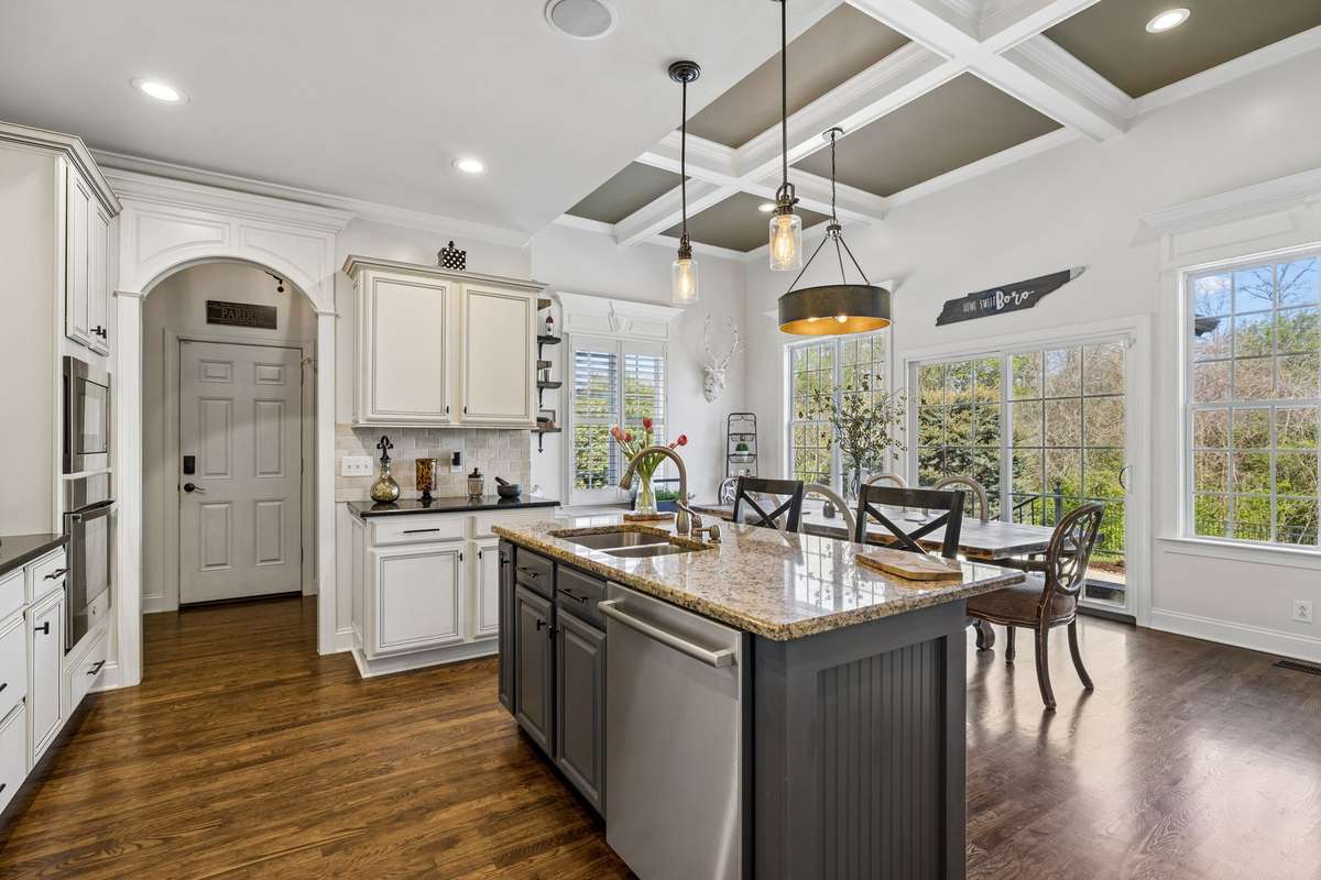 Entering kitchen with island overlooking breakfast/den area and backyard