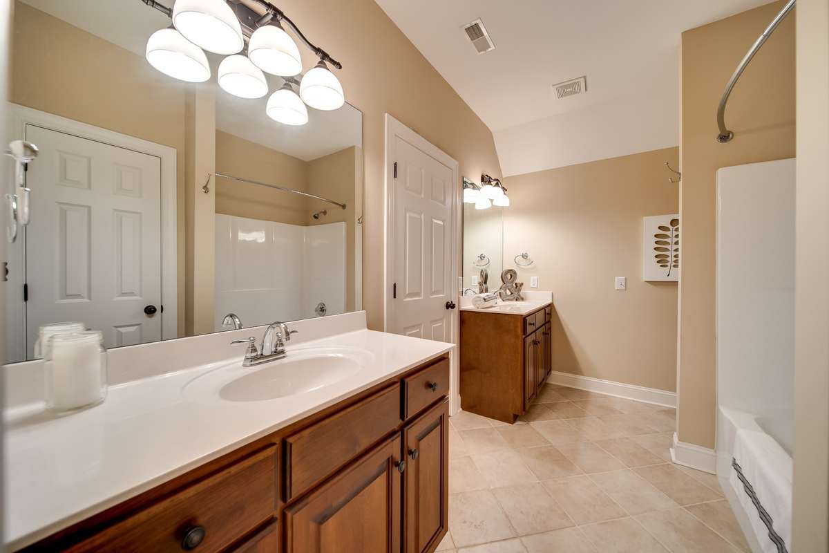Third full bathroom with separate vanities, linen closet, and full size door into the attic