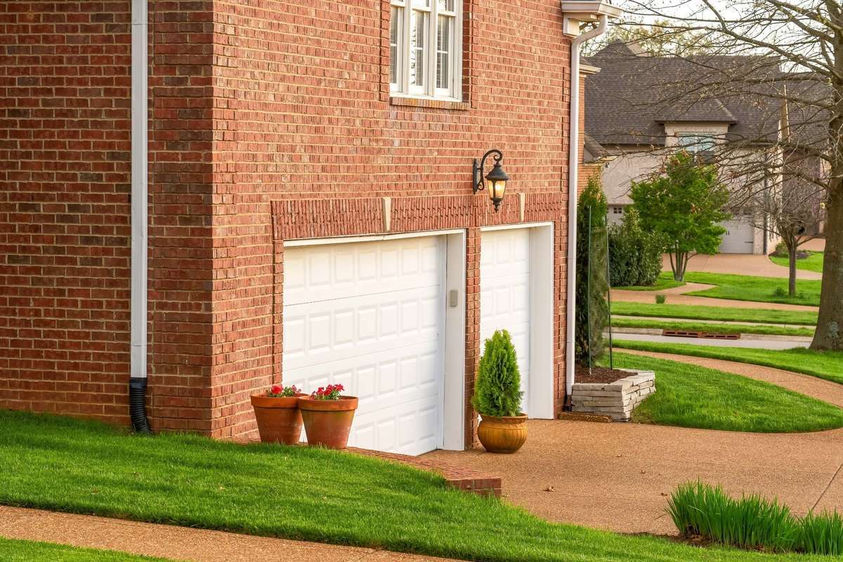 Three car garage with gently curving sidewalks to front and back porches