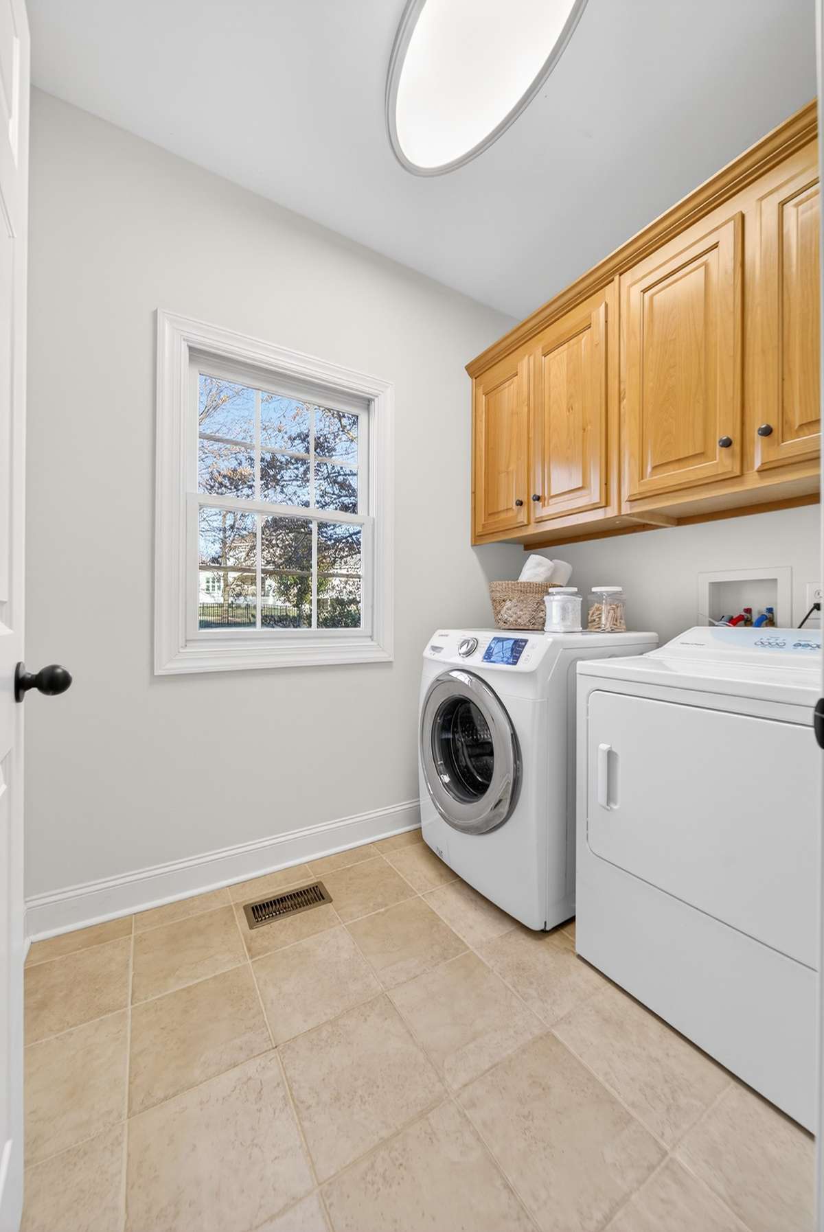 Laundry with light maple wood cabinets