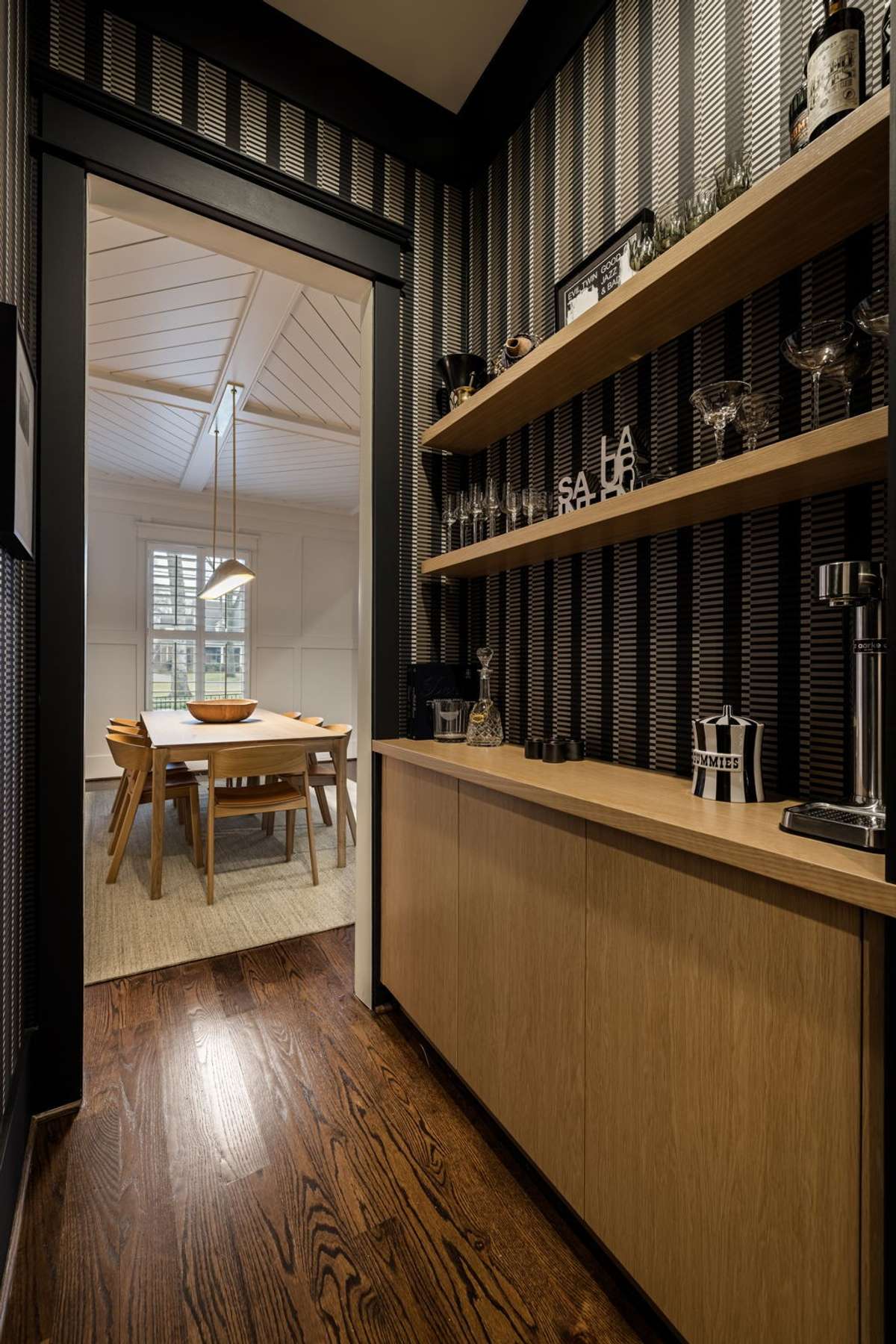 Pass-through bar with custom shelving and bold designer wall treatment