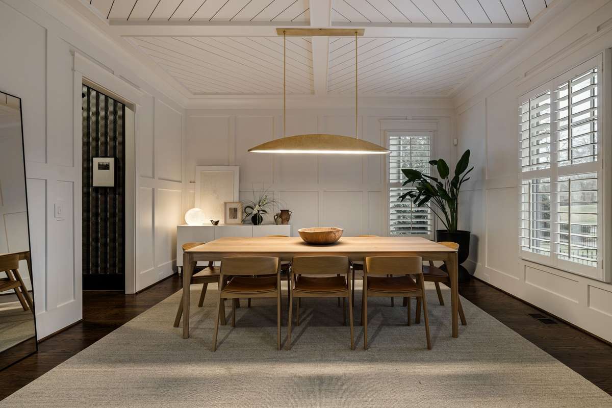 Dining room with paneled walls and statement lighting