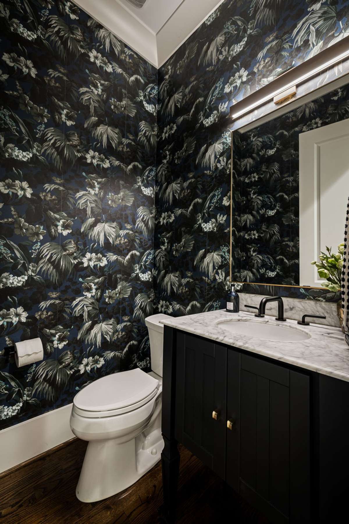 Powder bath with dramatic wallpaper and marble vanity