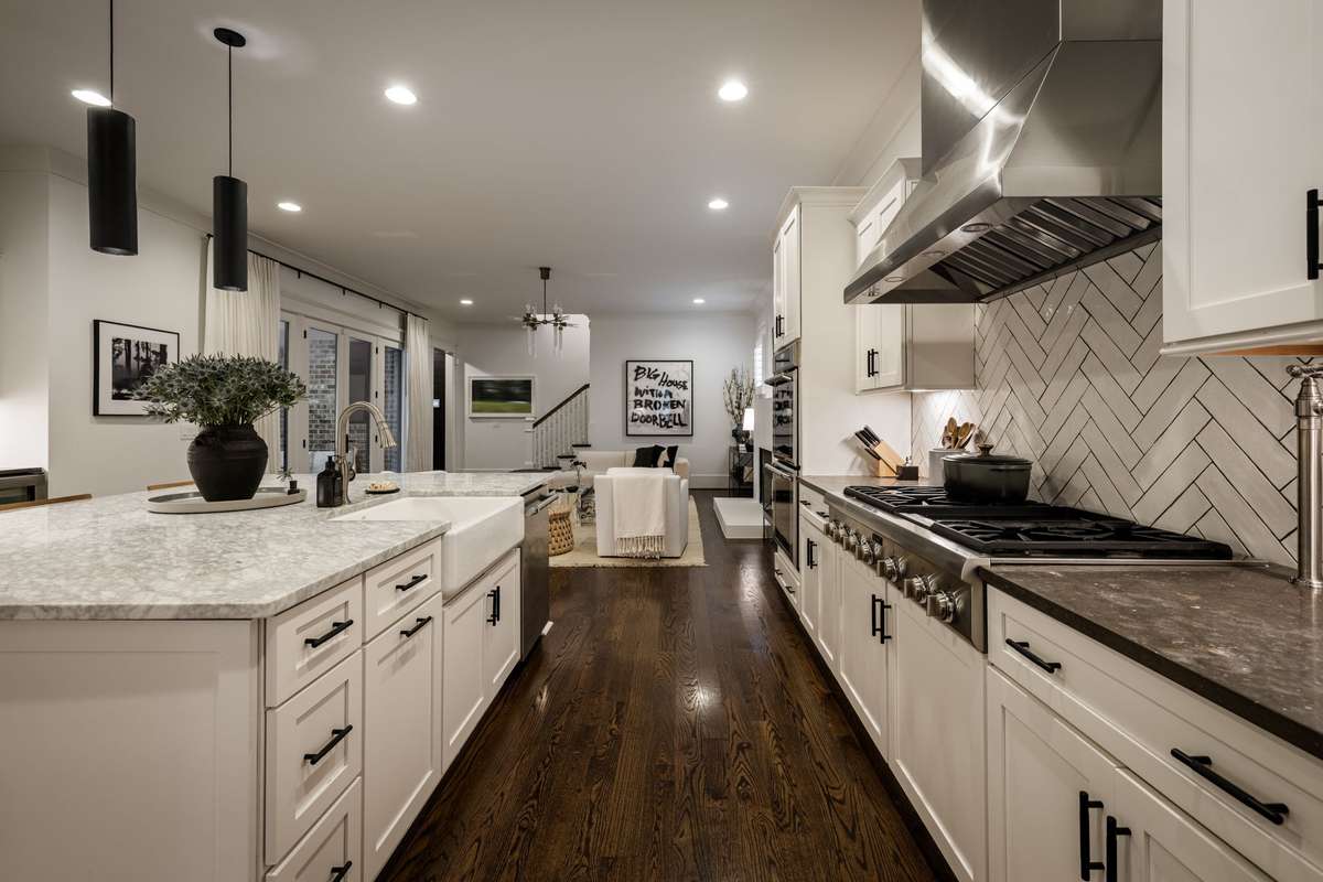 Kitchen with oversized island, professional-style range, and open flow to living