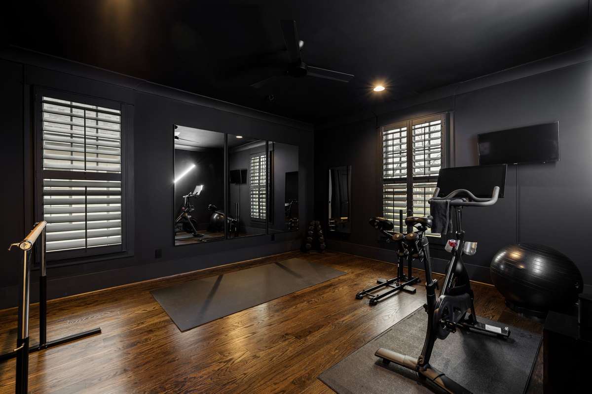 Home gym or flex room with mirrors and hardwood floors