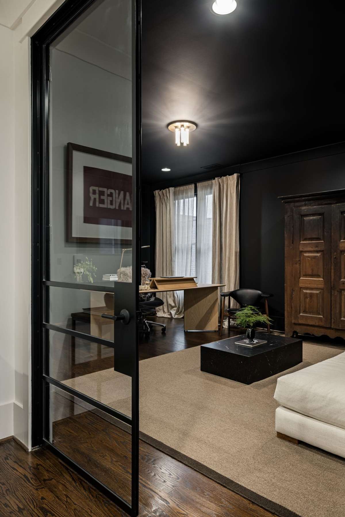 Private office with glass doors and moody, color-drenched walls