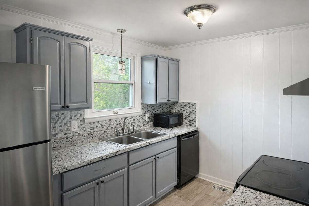 Updated kitchen with freshly painted cabinets, granite countertops, and natural light