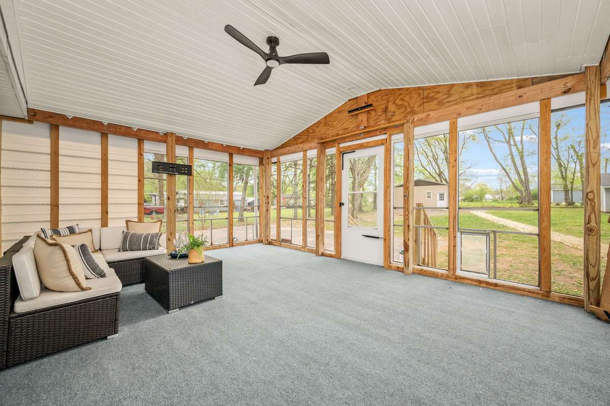 Covered, screened-in deck with ceiling fan and electric for a tv. New outdoor carpet makes this outdoor living space feel like part of the home.