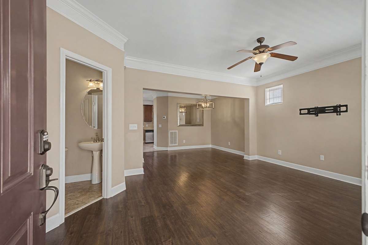 Entry view of the Great Room.  Easily accessible Half Bath.  View looking from front door through Great Room toward Dining Room.