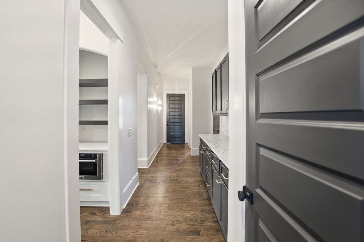 Main downstairs hallway small peek of butlers pantry leading to kitchen (on left)