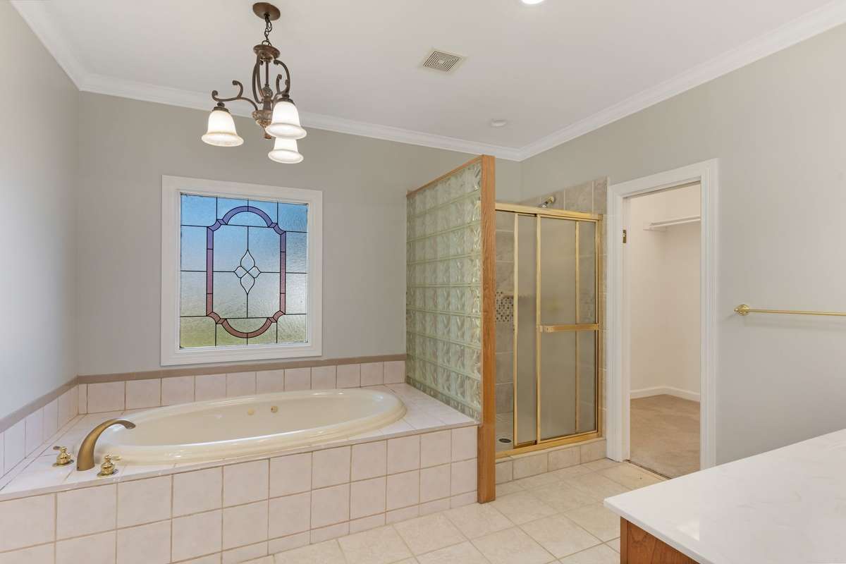 Primary bath with whirlpool tub, walk-in shower, walk-in closet, and solid surface double vanity.