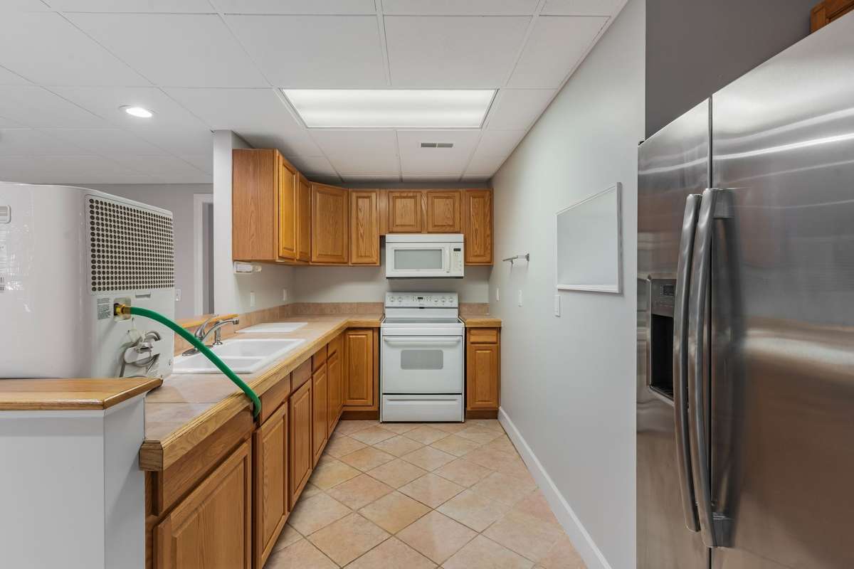 Basement full kitchen with tile flooring and custom hickory cabinetry.