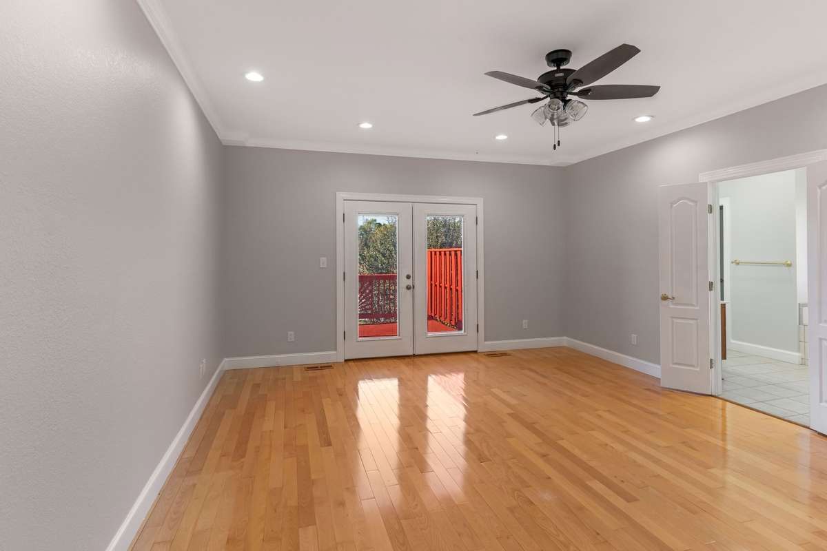 Main level primary opens to large deck overlooking pool.