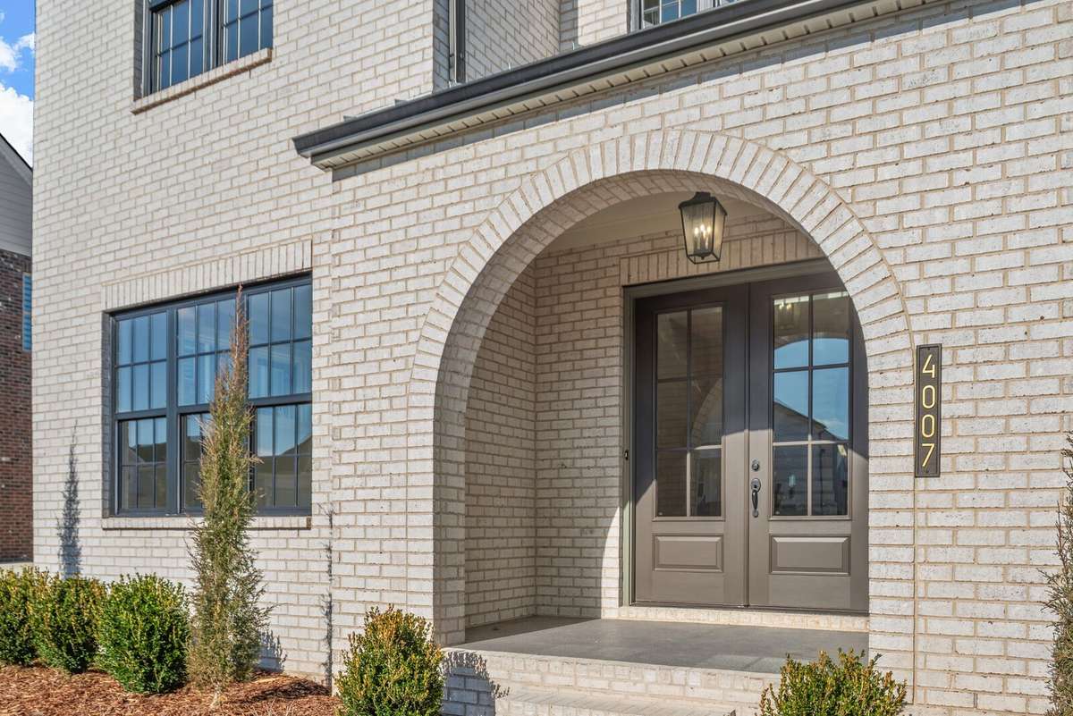Arched covered front porch has can lights in addition to the hanging fixture
