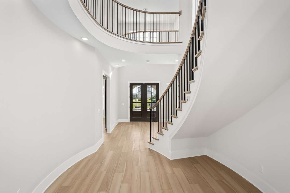 View of the front door from the hallway - also shows additional space below the stairs