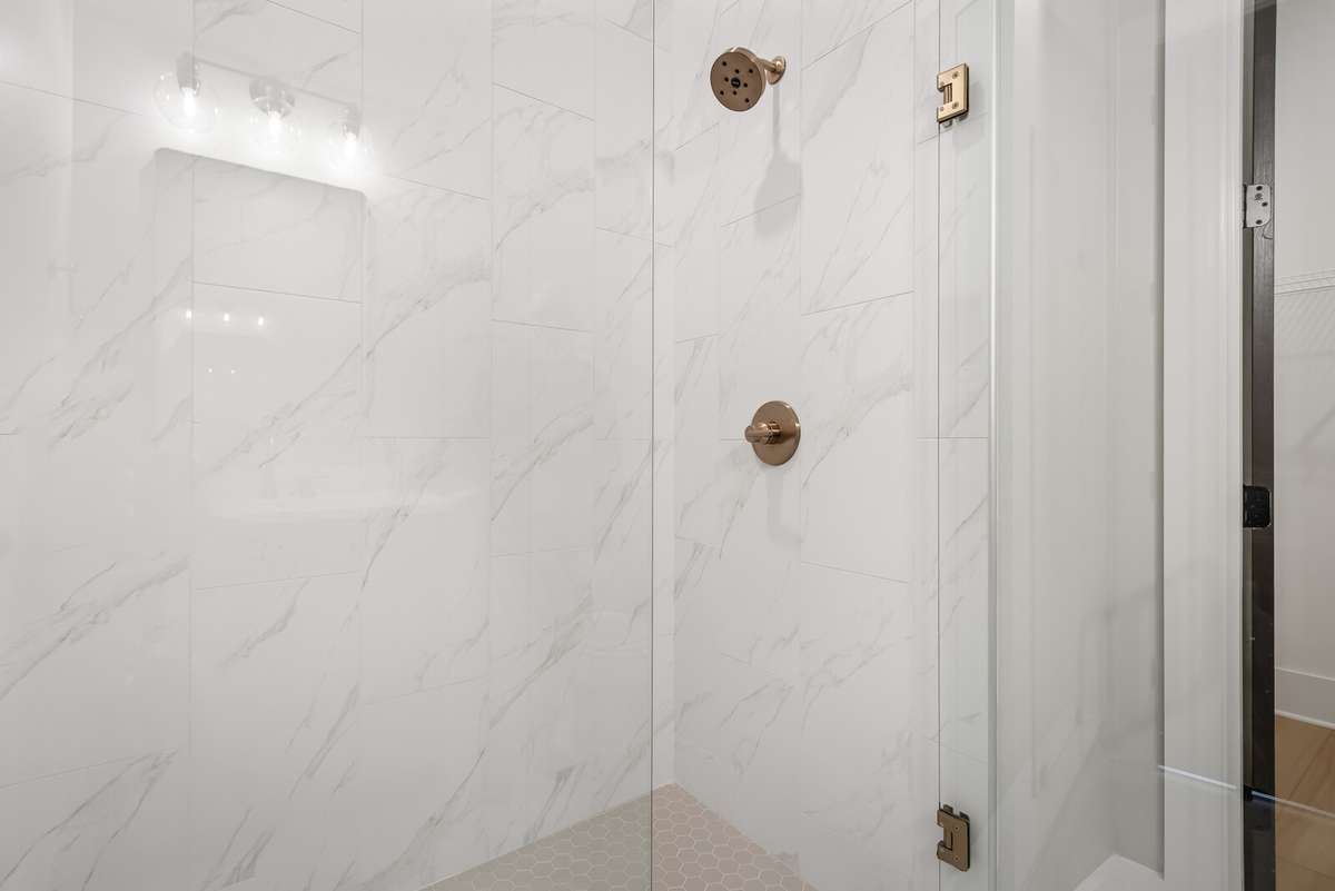 Full walk in shower with frameless glass door - main level secondary bedroom