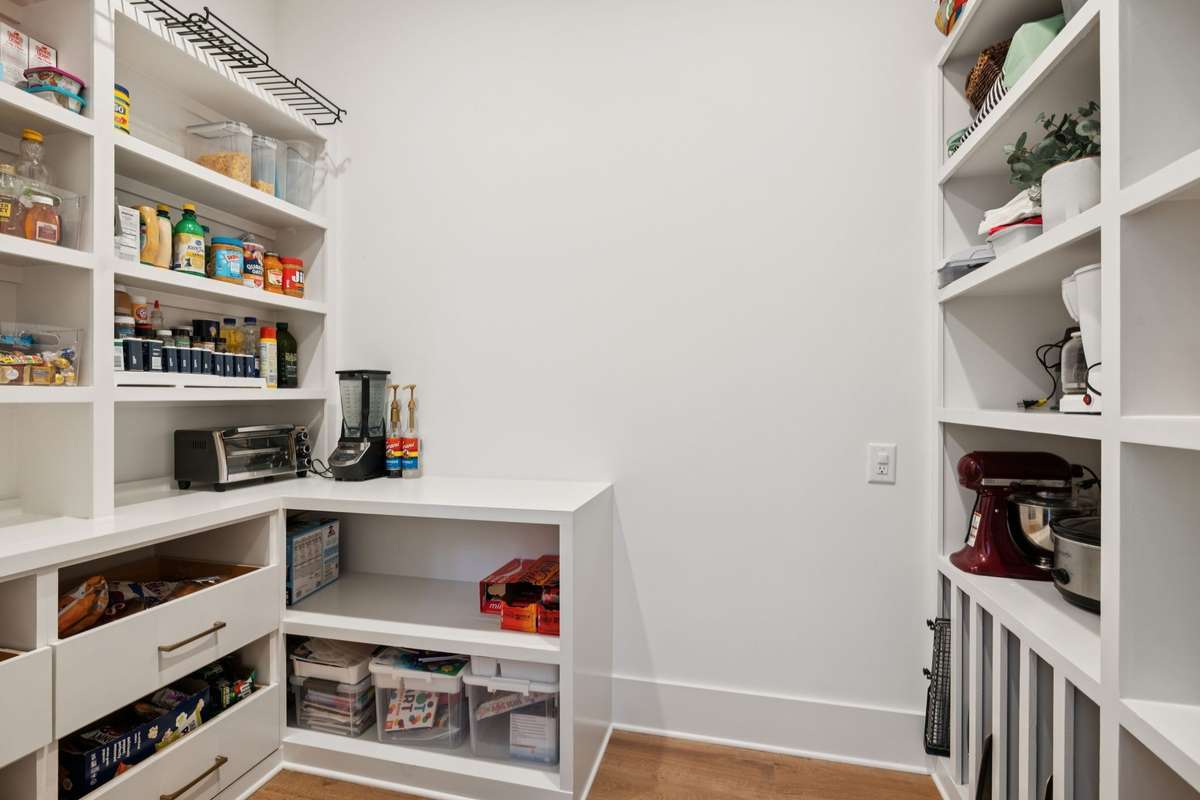 Oversized pantry is located through hidden cabinet doors to the right of the range.