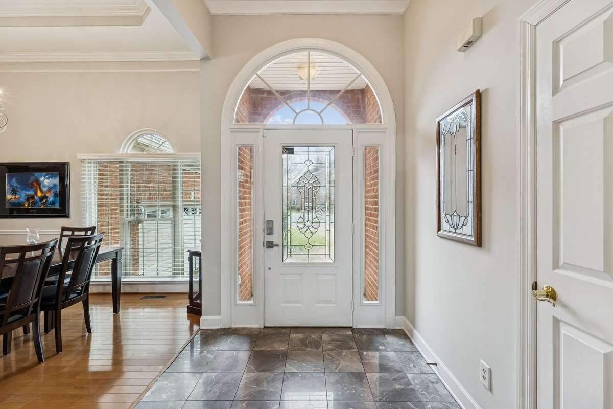 Bright, inviting entry with an arched transom, decorative glass front door, and classic tile flooring, making a stunning first impression the moment you step inside! 2409 Amber Glen Court, Murfreesboro, TN 37128