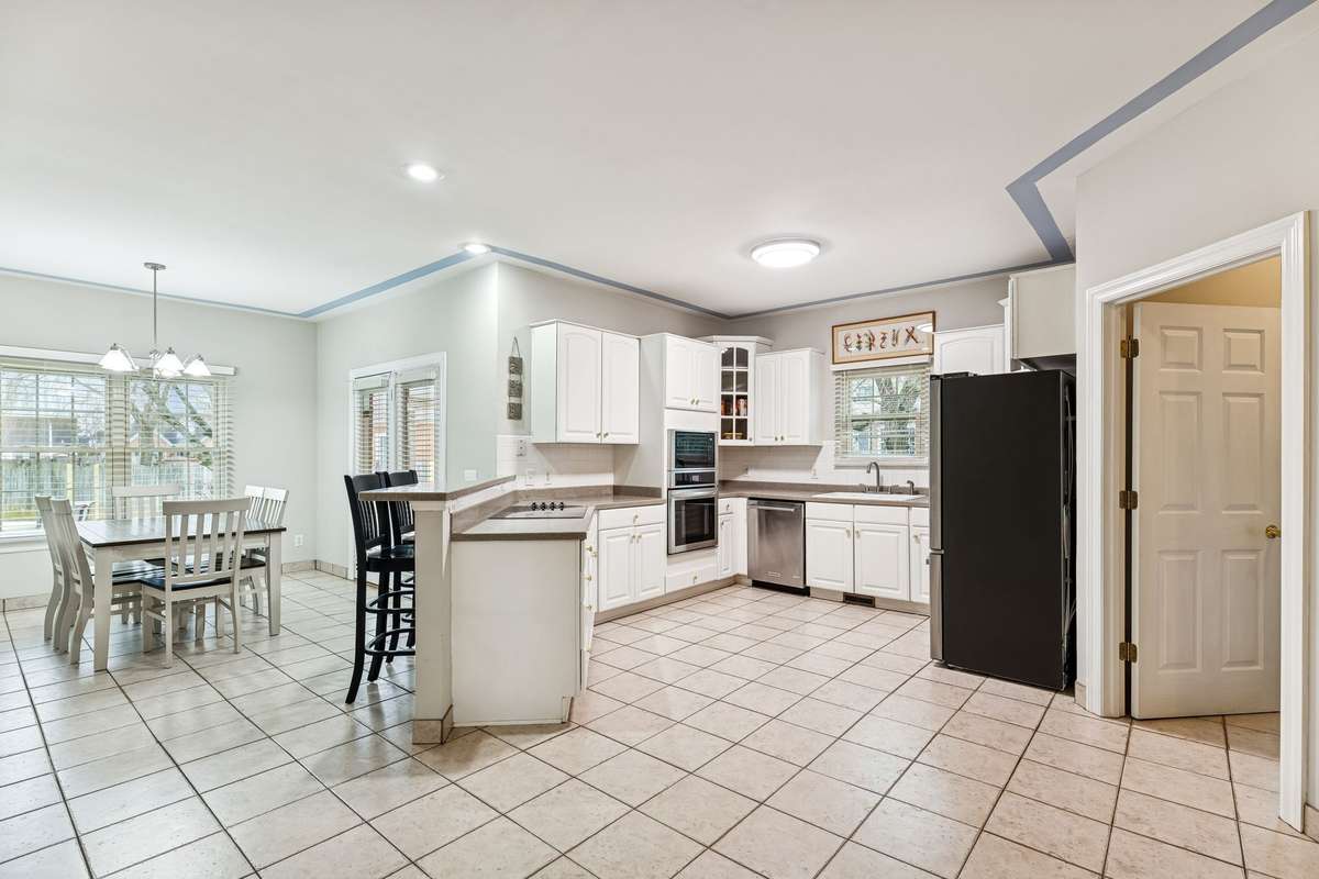 Spacious kitchen features tile flooring, solid surface countertops, a cooktop stove, built-in oven, and plenty of room to cook and entertain!  2409 Amber Glen Court, Murfreesboro, TN 37128