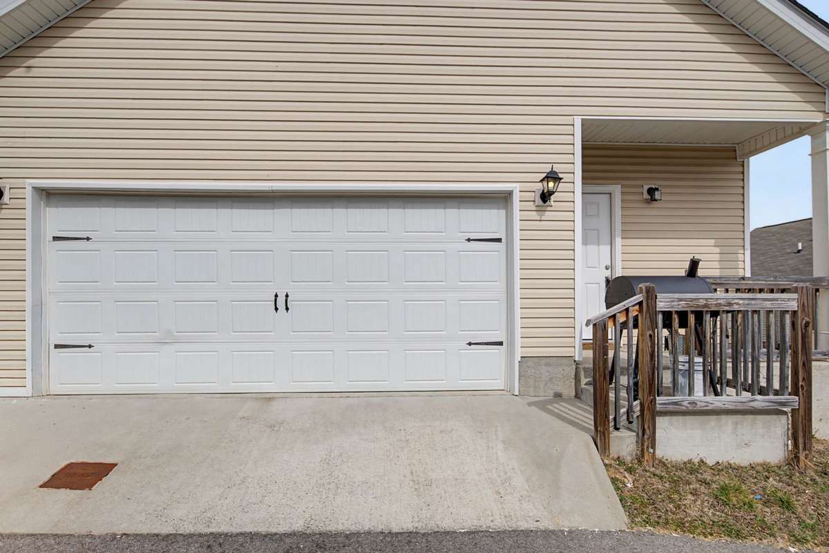 Two-car garage with clean concrete drive and easy access. Low-maintenance exterior and functional layout add everyday convenience.