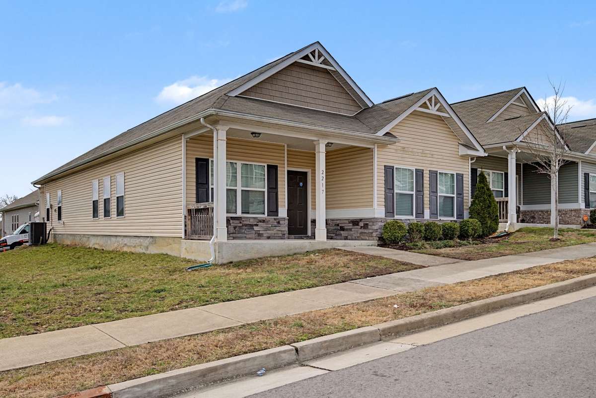 Charming single-level home featuring a covered front porch, stone-accent foundation, and low-maintenance vinyl siding. Situated on a corner-style lot with sidewalk access and attractive curb appeal.