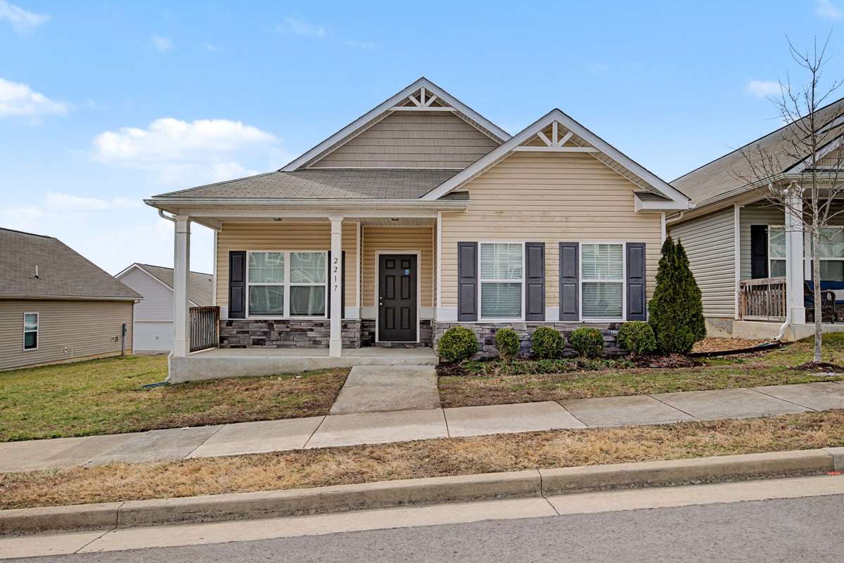 Inviting front elevation with classic gable details, shutters, and a welcoming covered porch.
