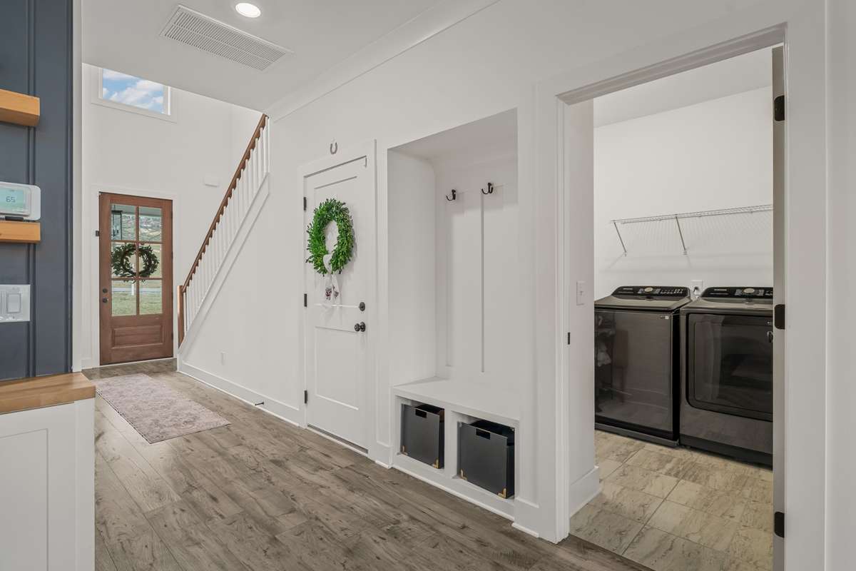 This view of the entry way also shows the entrace to the garage and laundry area. We love the small built-in hall tree nook for easily storing shoes, bags or coats.
