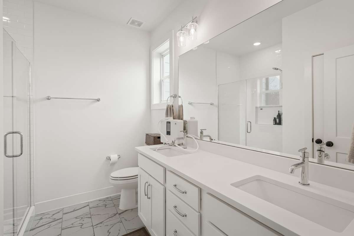 A sizeable primary bath with two vanities, plenty of cabinet space for those items that you want to store away.