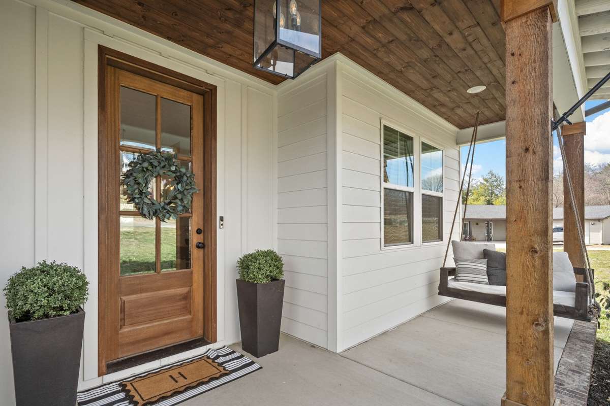This solid mahagony front is a show stopper along with the stained tongue and groove wooden ceiling. Wouldn't you love to sit on this covered front porch and drink your morning coffee?