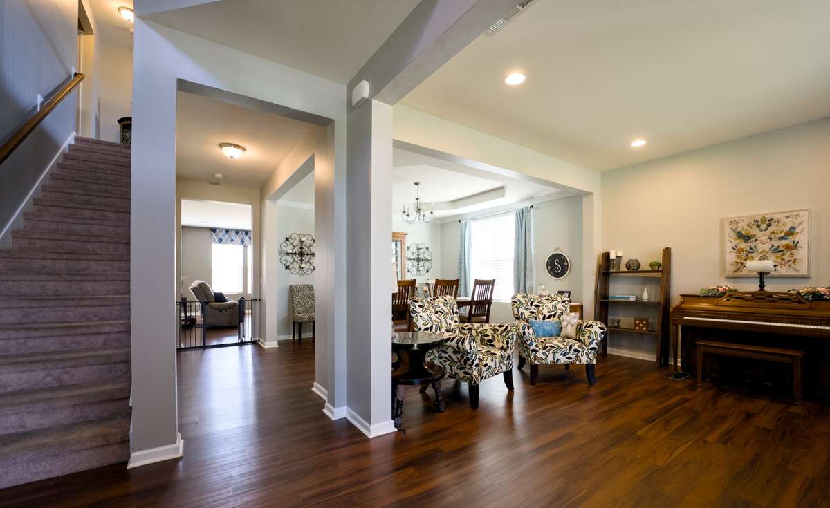 Main floor from the front entry accesses gathering room and formal dining area with stair leading to the second level.  New LPV flooring and fresh neutral paint.