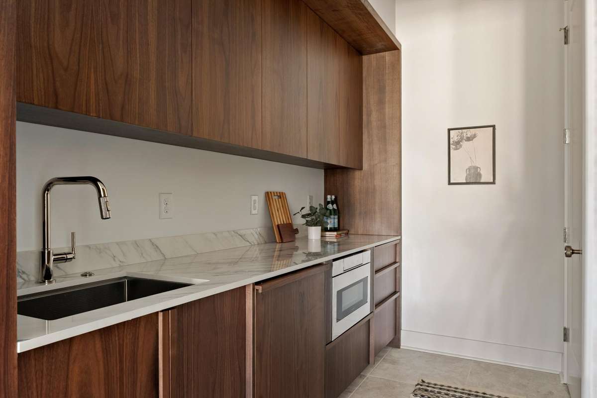 Scullery with a second dishwasher, paneled refrigerator, and abundant storage
