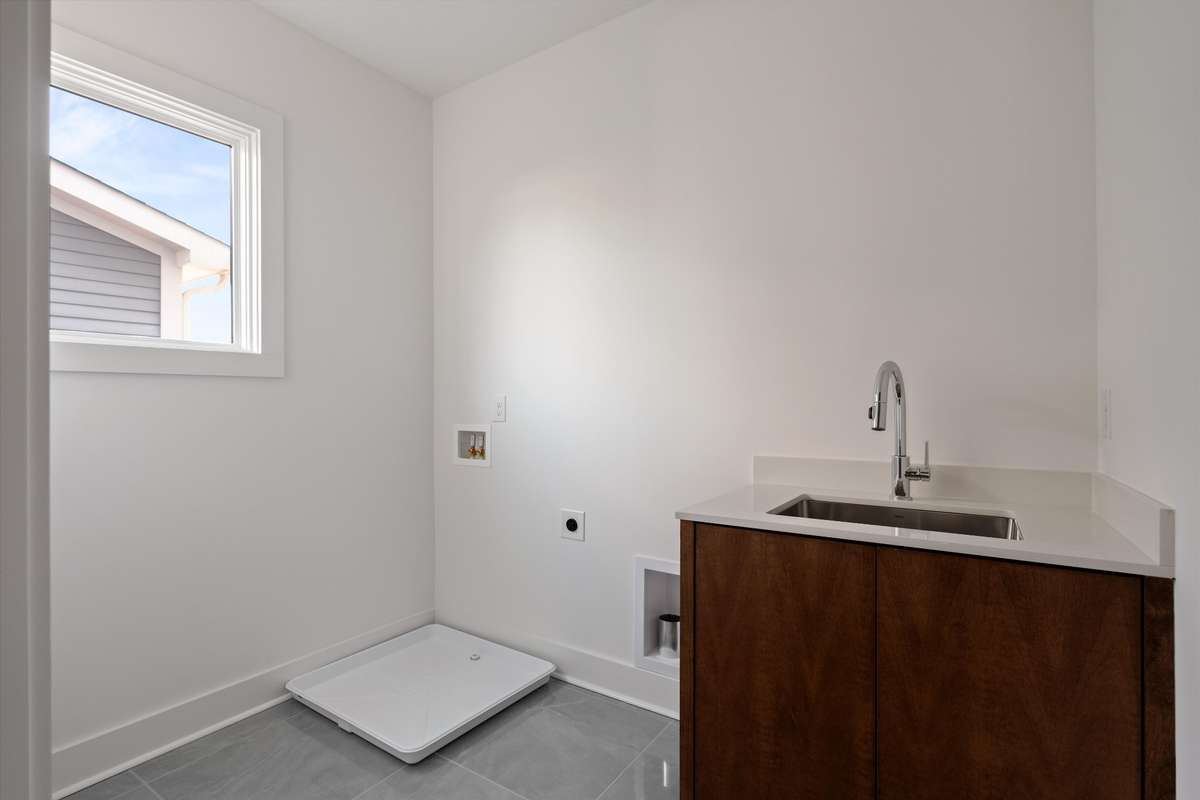 Full-size laundry room with sink off of primary bedroom