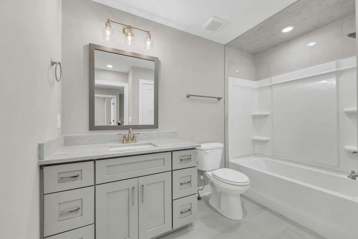 Hall Bathroom with granite countertops and tile surround