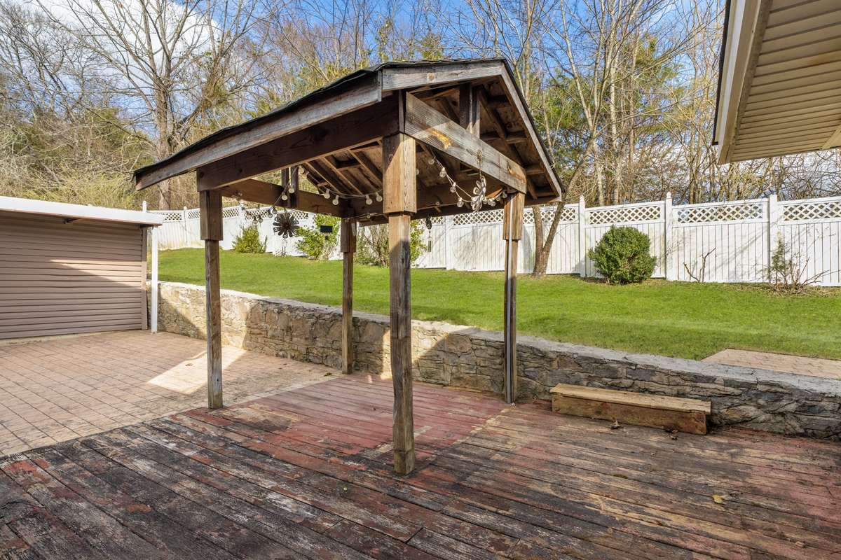 Outdoor wood deck with attached stamped concrete patio.