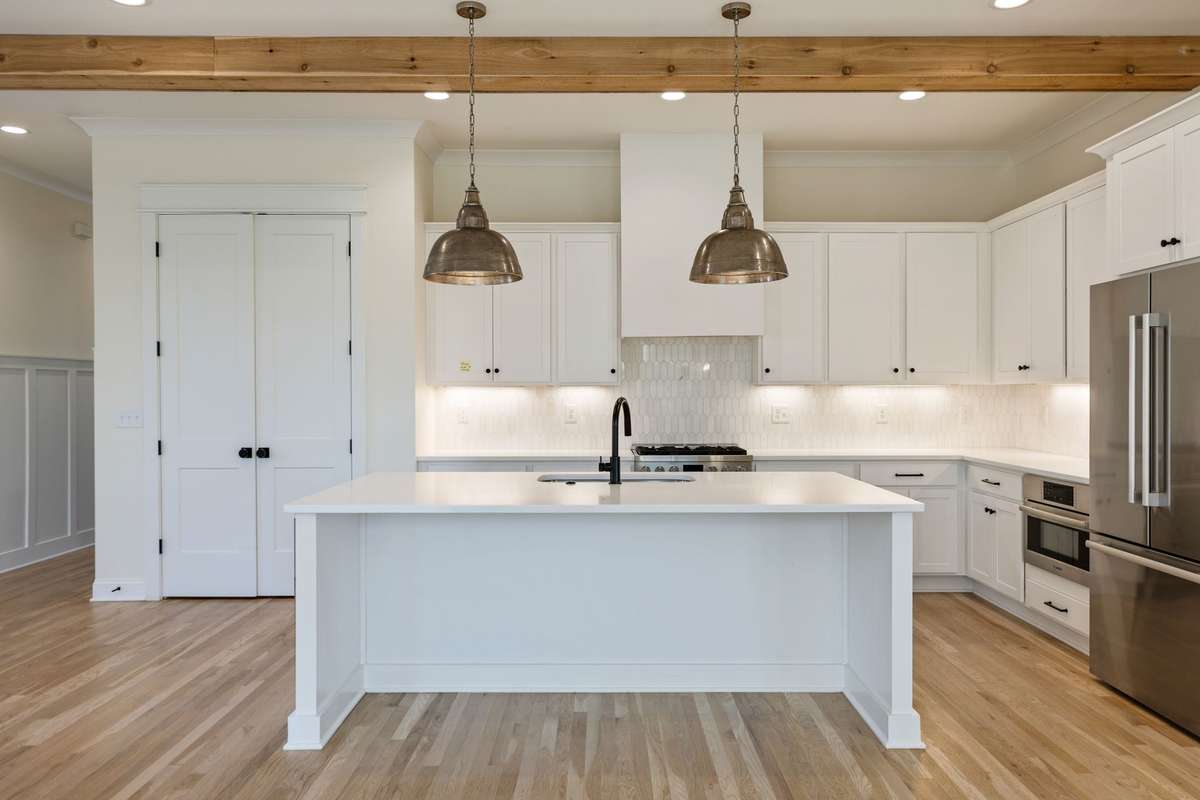 Stylish kitchen, Bosch stainless appliances, large island, gas range, large double door pantry, stunning pendant lighting, ample cabinetry.