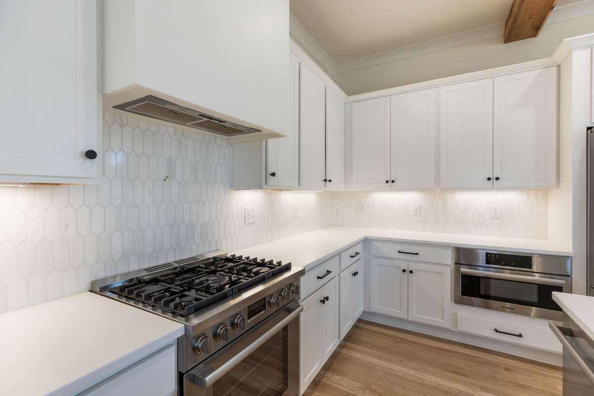 Gas range and beautiful backsplash. Venting above.