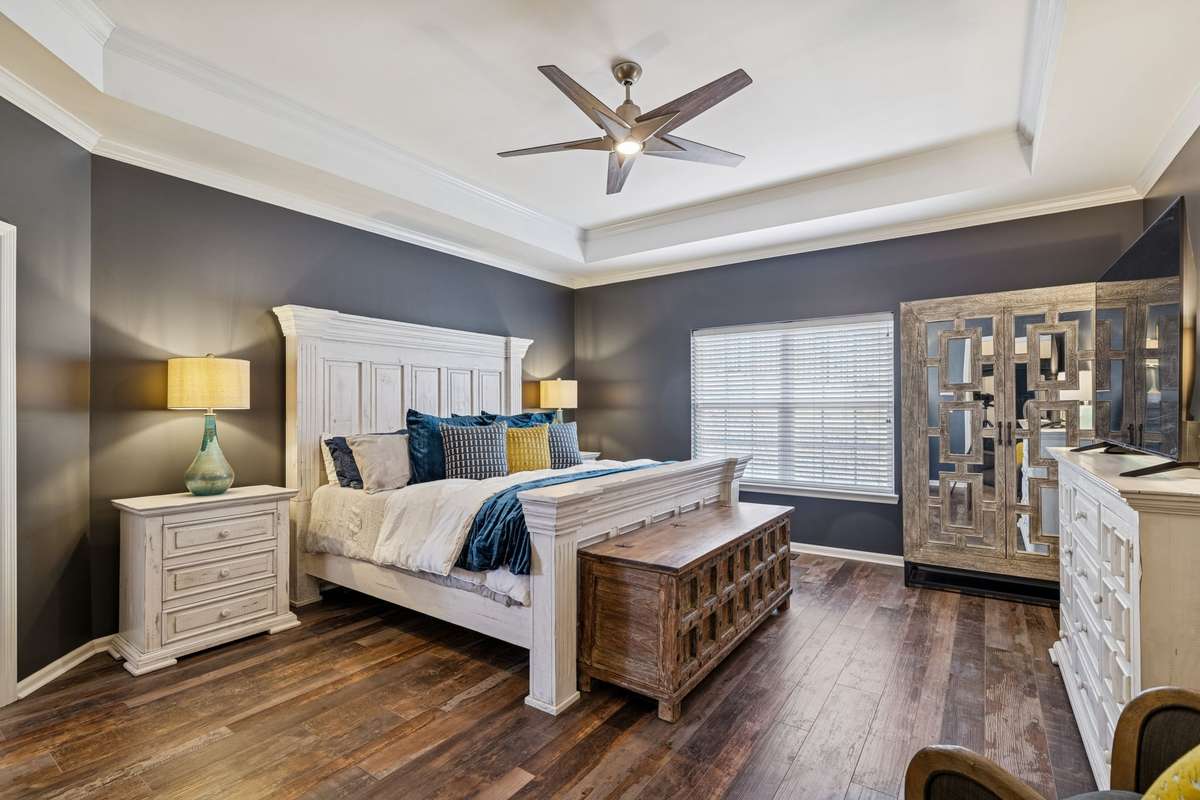 Primary Bedroom - Located on the main level, looking toward the back of the home.  You'll love the sophisticated feel of this space featuring the custom Trey Ceiling.