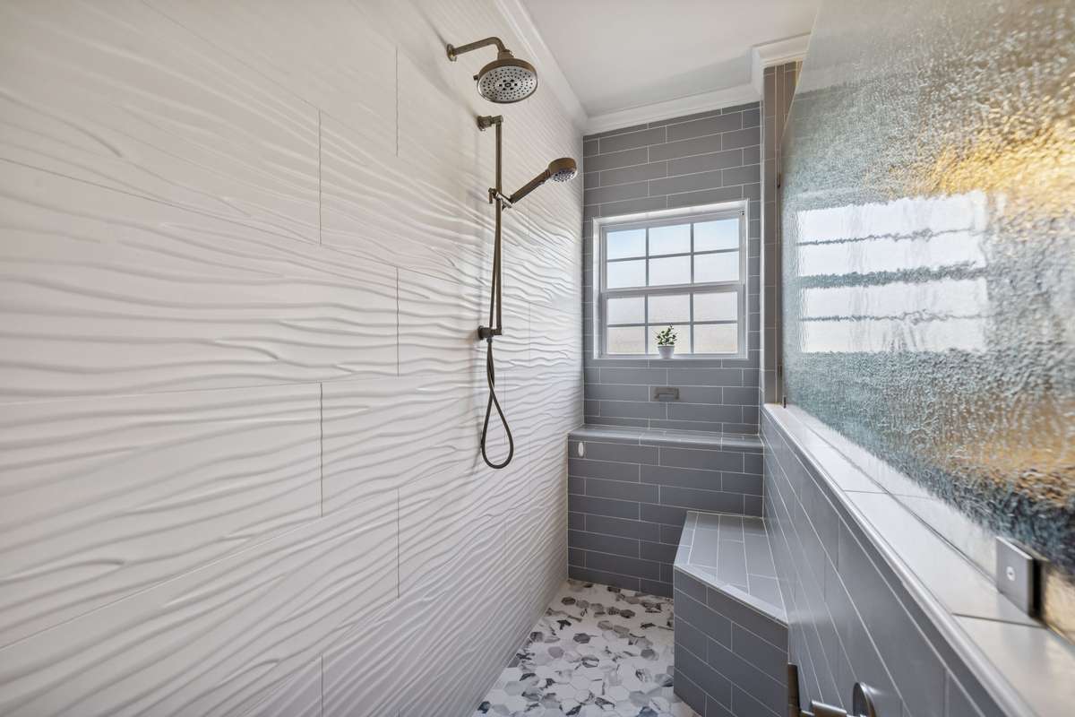 Primary Bathroom Shower - An experience everyone will love.  Dual shower heads with controls and seating to take in the full experience.